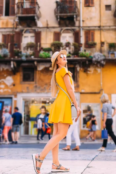 Девушка в желтом платье, солнцезащитные очки и лодочные позы на улицах — стоковое фото