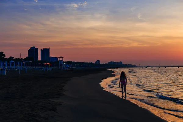 Young woman walking in sea. sunset, sea and sandy beach