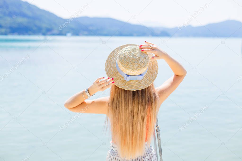Mountain lake. Girl admires views and holding hands on the boate
