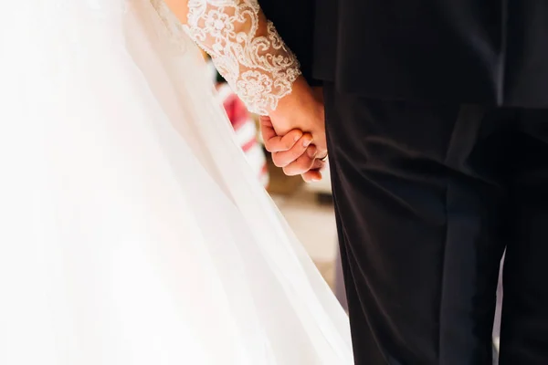 这是一对已婚夫妇手牵手的特写镜头。婚纱和婚纱 — 图库照片