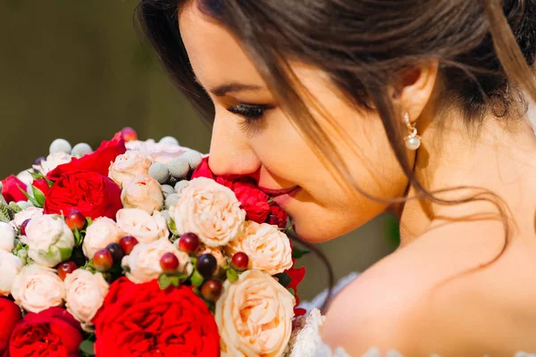 Güzel saç stili ve makyajlı bir gelin. Kokuyu içine çekiyor.