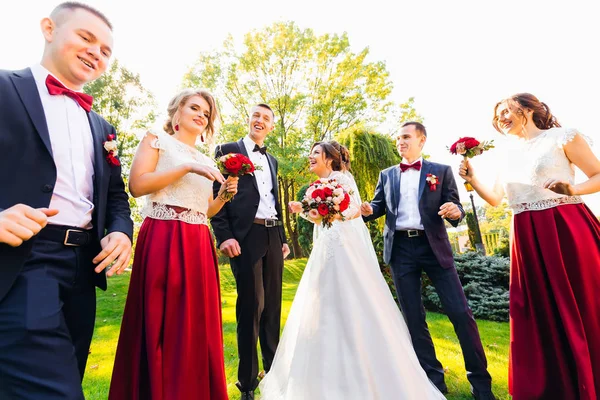 Yeni evliler ve onların arkadaşları parkta poz eğlenin. Düğün — Stok fotoğraf