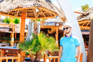 Hasır şapka ve güneş gözlüğü kafe yakınındaki sakallı adam