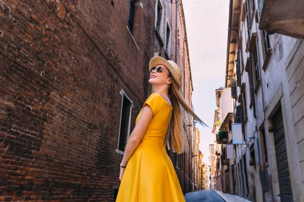 Stylish girls in a yellow dress and sunglasses looking at the bu — Stock Photo, Image