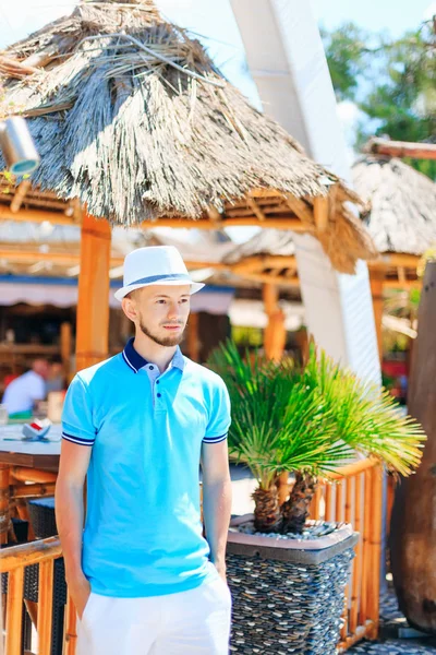 Giyen polo ayakta bungalov yakınındaki bir genç adam. Bu adamla