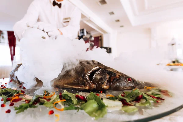 El camarero vierte agua hirviendo en nitrógeno. Peces rellenos. Boda. — Foto de Stock