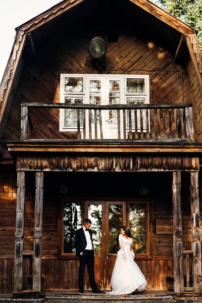 Wedding couple standing on the porch of wooden building. boho we — Stock Photo, Image