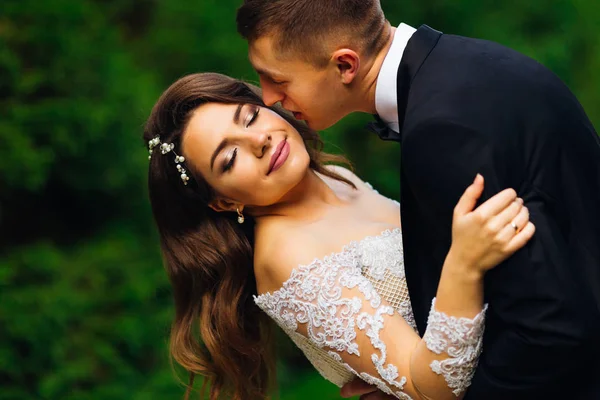 A noiva com uma bela maquiagem fecha os olhos e o noivo — Fotografia de Stock