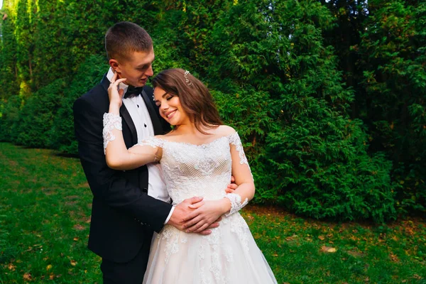 El novio abraza a la novia desde la parte trasera. soborno con make — Foto de Stock