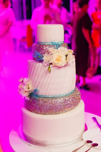 Hermoso pastel de bodas con flores en la sala del restaurante. mujer alta —  Fotos de Stock