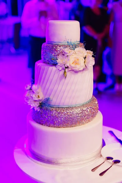 Piękny tort weselny z kwiatami w sali restaura. Wysoki — Zdjęcie stockowe