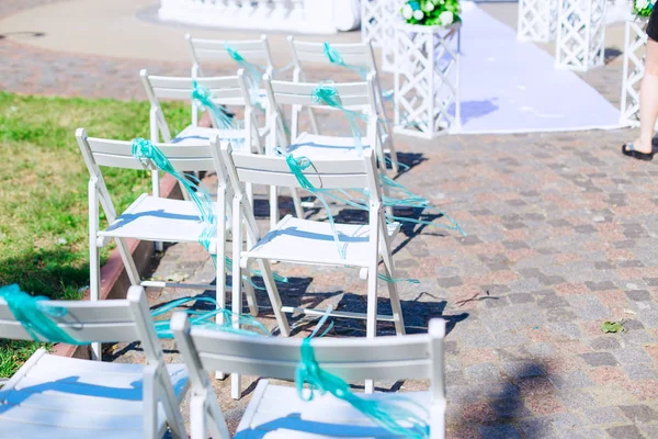 Close-up of white armchairs with turquoise bow. sunny day — Stock Photo, Image