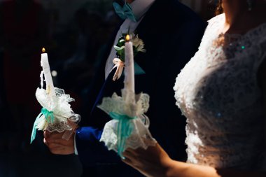 Kilisedeki yeni evliler yanan mumlar tutuyor. düğün töreni