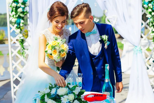 Noiva e noivo perto do arco com decorações de casamento. tabela com w — Fotografia de Stock