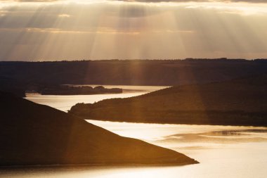 nehir ve günbatımı sarma. Sahildeki tepeler kaplıdır