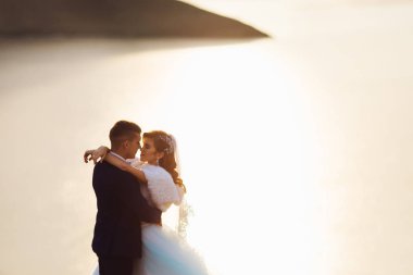 yeni evliler kucakladı ve gözleri kapalı. güneş ışığı ve blurr