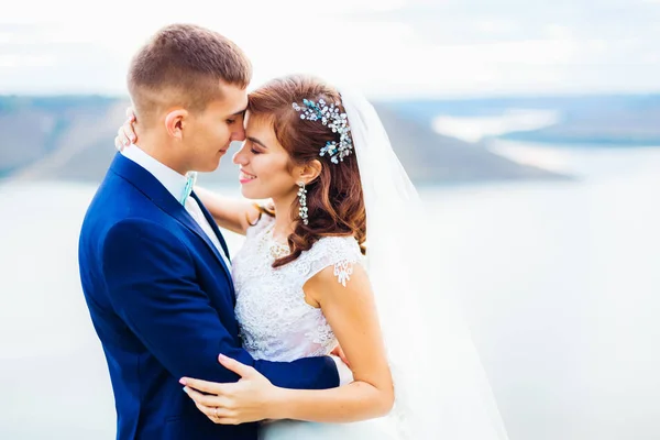 Bella sposa con abito e velo da sposa occhi chiusi e abbraccio — Foto Stock