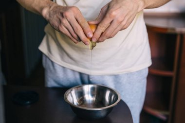 Mutfakta şef yemek. elinde kırık yumurta. üzerinde kase