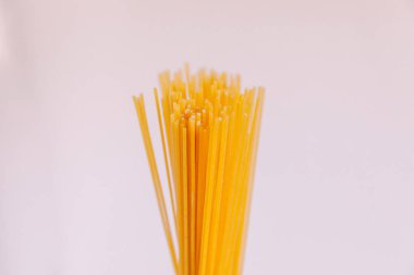 Çiğ makarna Beyaz arka planda bir elde makarna. Kapat.