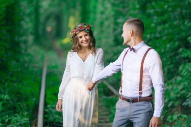 Çift el tutarak ve demiryolu boyunca yürüyüş. bir kız 