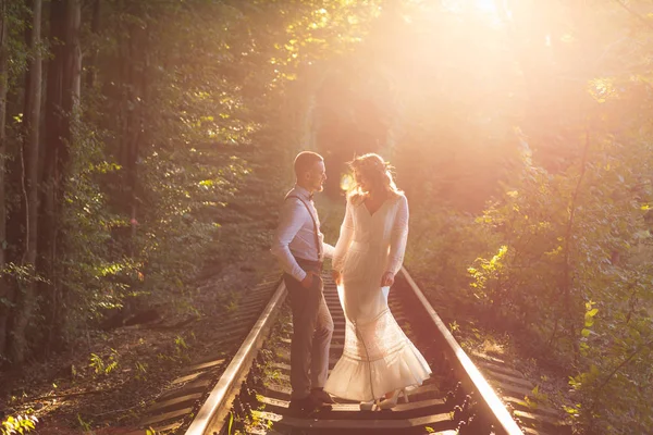 Par i festliga kläder står på järnväg och titta på EA — Stockfoto
