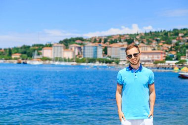güneş gözlüğü sakallı adam ceplerinde el ele tutuşup gülümsüyor. adam o