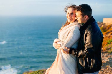 Bir adamın yakın çekim kıyıda arka taraftan bir kadın kucaklar