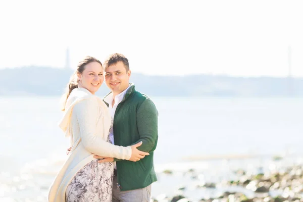 Chica y chico abrazando y mirando la lente de la cámara en el río — Foto de Stock