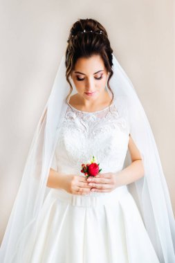 güzel gelin elinde bir boutonniere tutar. b üzerinde gelin