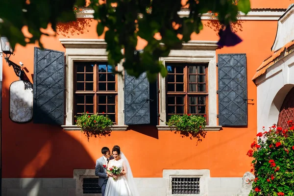 Novomanželé v zahradě na pozadí vestavěného — Stock fotografie