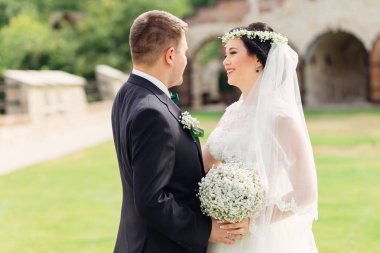 başında bir çelenk ile güzel gelin damat bakar ve