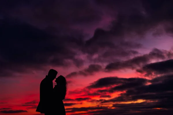 Silhouette of the guy and the girl who standing face to face aga