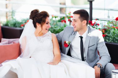 Yeni evliler eğlenir ve restoranda kanepede otururken