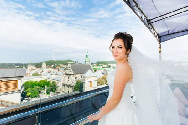 Divatos menyasszony az erkélyen. panoráma nyílik a városra. menyasszony csodáló — Stock Fotó