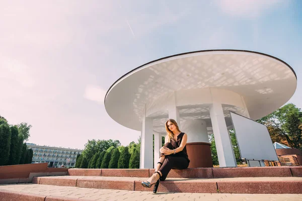 Belle fille assise sur les escaliers et regardant dans la caméra — Photo