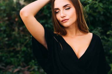 Siyah elbiseli, yakın plan bir kız. Gözlerini kapadı.