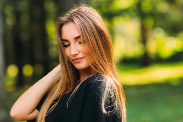 Una ragazza bruna con un trucco guarda giù e tiene la mano dentro — Foto Stock