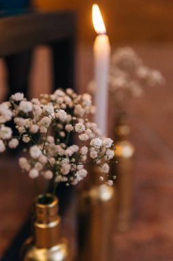 ışıklı mum ve vazo da beyaz çiçeklerbir dalı. yakın çekim