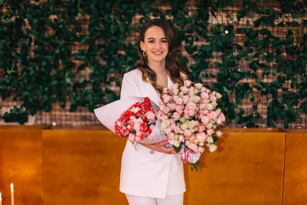 master of ceremonies look at camera and hold bouquet of flowers