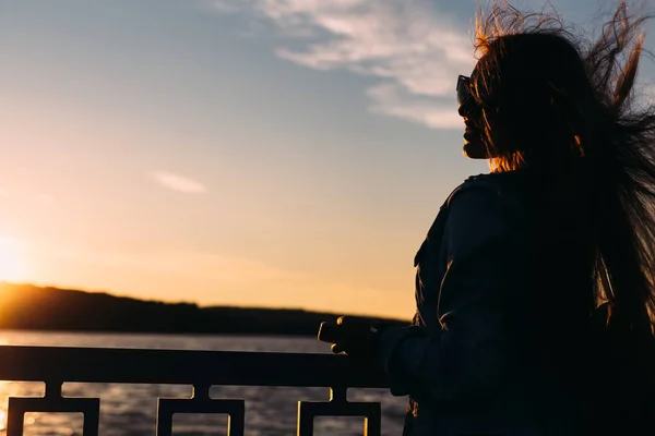 Menina elegante em óculos de sol perto da cerca do lago. menina sorri e — Fotografia de Stock