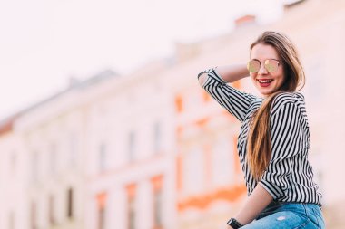  Sokakta eğlenen güzel bir kız. Güneş gözlüğü takan bir kız.