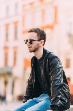 Siyah deri ceketli, sakallı genç adam.