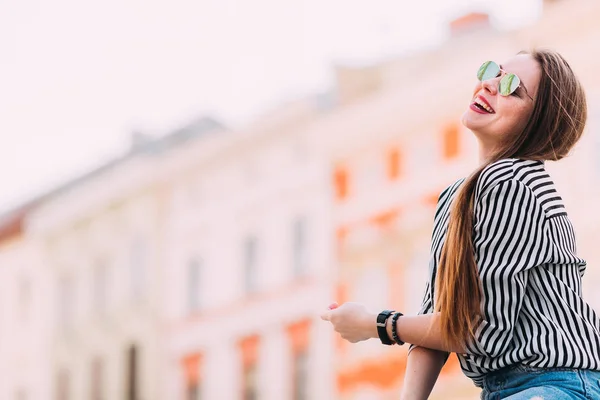 Feche de mulher feliz em óculos escuros. Sorri. edifício da cidade — Fotografia de Stock