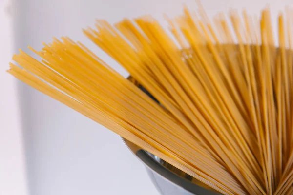 Сире спагеті в металевій мисці на білому тлі . — стокове фото