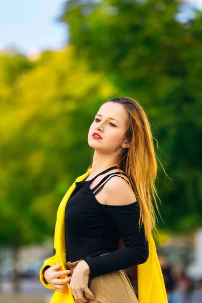 Moda donna. ragazza in camicetta nera e cappotto giallo sul suo shoul — Foto Stock