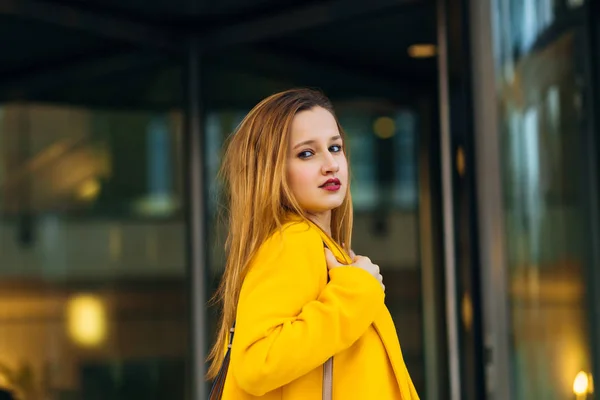 Primo piano di una ragazza con un bel trucco in un cappotto giallo — Foto Stock