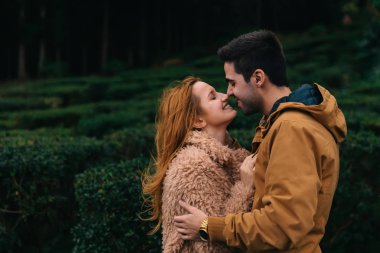 Sakallı adam bir kıza sarılıyor ve gözlerini kapatıyorlar. Öpmek istiyorum..