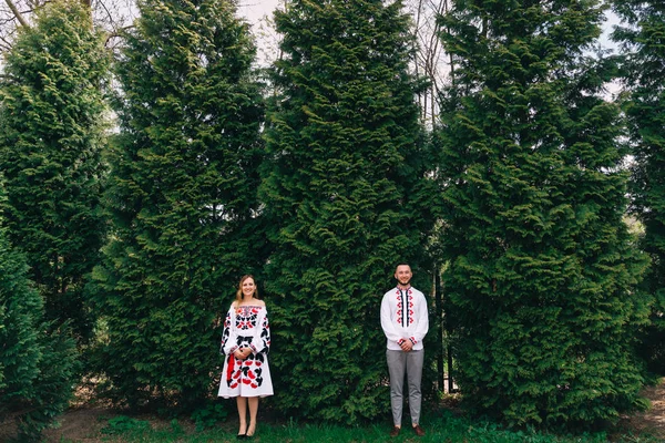 Хлопець і дівчина стоять біля дерев і дивляться на камеру. вбудувати — стокове фото
