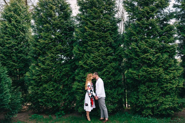 Homme et fille en vêtements brodés embrassant les arbres. engager — Photo