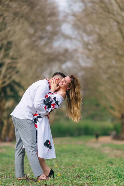 Le mec embrasse et embrasse la fille. vêtements brodés. parc . — Photo